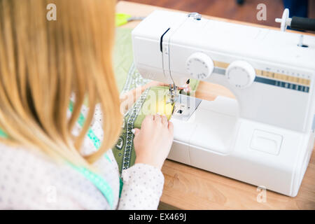 Closeup portrait of female tailor using a sewing machine Stock Photo