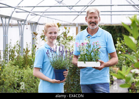 Portrait Of Staff At Garden Center Holding Plants Stock Photo