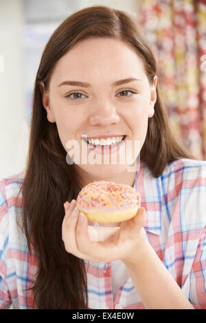 Portrait Of Smiling Teenage Girl On Eating Donut Stock Photo