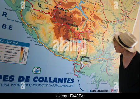 Horizontal view of a tourist looking at the Topes de Collantes National Park map at the visitor centre in Cuba. Stock Photo