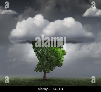 Head in the cloud concept as a tree shaped as the face of a person with clouds covering the top as an imagination metaphor for contemplation and meditation or negative and negativity character trait. Stock Photo