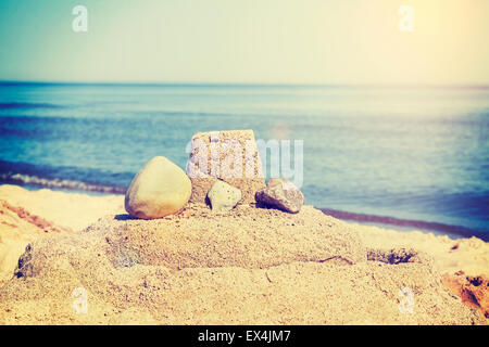 Vintage retro toned simple sandcastle on a beach, summer holidays concept. Stock Photo