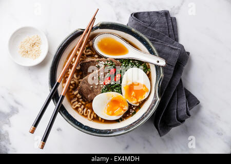 Miso Ramen Asian noodles with beef and egg in bowl on white marble background