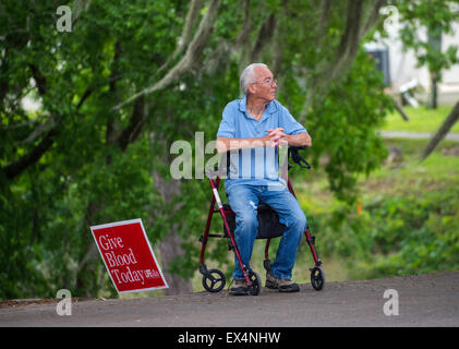 Elderly man sits on his walker by a blood donation sign at Pioneer Days Festival in the North Florida town of High Springs. Stock Photo