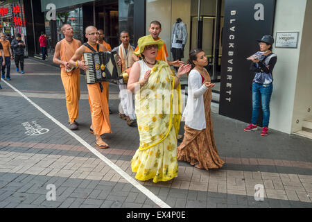 Devotees from Hare Krishna play music and sing on the street, in Hong Kong, China Stock Photo