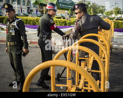 Bangkok, Thailand. 07th July, 2015. Thai police walk through a military checkpoint in front of the Ministry of Defense in Bangkok before a rally to support students arrested by the military. About 100 people gathered in front of the Ministry of Defense in Bangkok Tuesday to support 14 university students arrested two weeks ago for violating orders against political assembly. They're facing criminal trial in military courts. Credit:  ZUMA Press, Inc./Alamy Live News Stock Photo