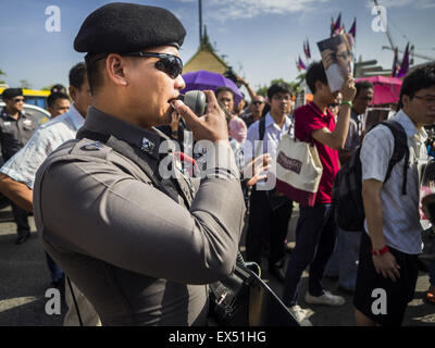 Bangkok, Thailand. 07th July, 2015. A Thai police officer makes announcements to people gathered at the Ministry of Defense in defiance of military orders against political rallies. At least two people were arrested during the rally. About 100 people gathered in front of the Ministry of Defense in Bangkok Tuesday to support 14 university students arrested two weeks ago for violating orders against political assembly. They're facing criminal trial in military courts. Credit:  ZUMA Press, Inc./Alamy Live News Stock Photo