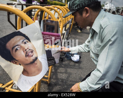 Bangkok, Thailand. 07th July, 2015. A man looks at the pictures of students arrested by the Thai junta during a rally in support of the students. The pictures were hung on a barricade in front of the Ministry of Defense. About 100 people gathered in front of the Ministry of Defense in Bangkok Tuesday to support 14 university students arrested two weeks ago for violating orders against political assembly. They're facing criminal trial in military courts. Credit:  ZUMA Press, Inc./Alamy Live News Stock Photo