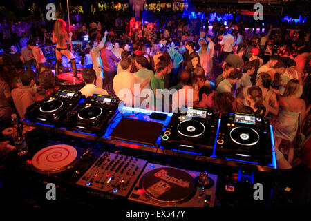 Music / sound mixing decks in foreground and dancing people in a nightclub in Athens, Greece Stock Photo