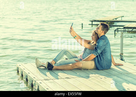 Couple in love sitting on the pier, selfie