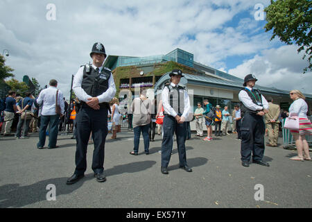 Wimbledon, London, UK. 07th July, 2015. Police officers and  spectators stand in  a one minute silence at 11.30am outside the gates of the AELTC on the tenth anniversary of the July 7 terror bombings in London. 7/7. London bombing victims. 10 year anniversary.  Credit:  amer ghazzal/Alamy Live News Stock Photo