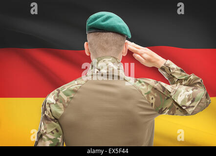 Soldier in hat facing national flag series - Germany Stock Photo