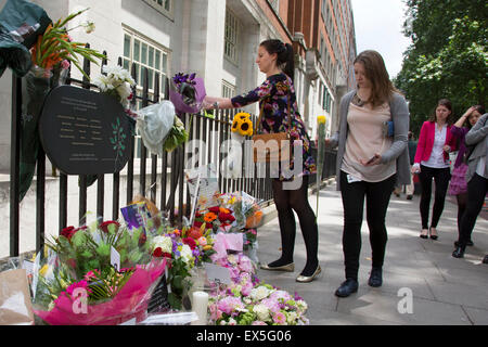 London, UK. 7th July, 2015. 10th anniversary of the London 7/7 bombings. Flowers are laid in memory of the victims of the terrorist attack in London. Here the memorial on Tavistock Square, where the bus bombing took place. Passers by gather to read the cards in memorial, and others to lay flowers. The 7 July 2005 London bombings (often referred to as 7/7) were a series of coordinated suicide bomb attacks in central London, which targeted civilians using the public transport system during the morning rush hour. Credit:  Michael Kemp/Alamy Live News Stock Photo