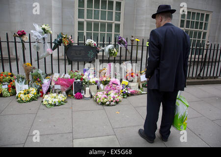 London, UK. 7th July, 2015. 10th anniversary of the London 7/7 bombings. Flowers are laid in memory of the victims of the terrorist attack in London. Here the memorial on Tavistock Square, where the bus bombing took place. Passers by gather to read the cards in memorial, and others to lay flowers. The 7 July 2005 London bombings (often referred to as 7/7) were a series of coordinated suicide bomb attacks in central London, which targeted civilians using the public transport system during the morning rush hour. Credit:  Michael Kemp/Alamy Live News Stock Photo