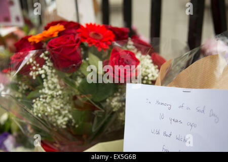 London, UK. 7th July, 2015. 10th anniversary of the London 7/7 bombings. Flowers are laid in memory of the victims of the terrorist attack in London. Here the memorial on Tavistock Square, where the bus bombing took place. Passers by gather to read the cards in memorial, and others to lay flowers. The 7 July 2005 London bombings (often referred to as 7/7) were a series of coordinated suicide bomb attacks in central London, which targeted civilians using the public transport system during the morning rush hour. Credit:  Michael Kemp/Alamy Live News Stock Photo