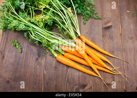 Fresh carrots arranged on dark wood table Stock Photo