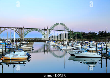 Boats moored in Port of Newport Marina and Yaquina Bay Bridge, Newport, Oregon USA Stock Photo