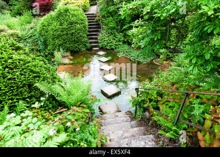 Steps and stepping stones leading across a stream at Alton Towers Estate Theme Park Gardens Staffordshire England UK Stock Photo