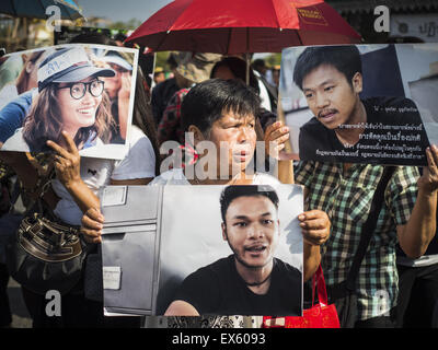 Bangkok, Thailand. 07th July, 2015. Activists rally at the Ministry of Defense and hold photos of the 14 students arrested by the military. About 100 people gathered in front of the Ministry of Defense to support 14 university students arrested two weeks ago for violating orders against political assembly. They're facing criminal trial in military courts. The courts ordered their release Tuesday because they can only be held for two weeks without trial, the two weeks expired Tuesday and the military court chose not to renew their pretrial detention. Credit:  ZUMA Press, Inc./Alamy Live News Stock Photo