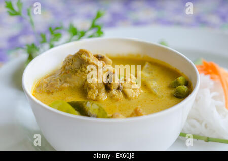 yellow chicken curry in bowl served with fresh vegetable Stock Photo