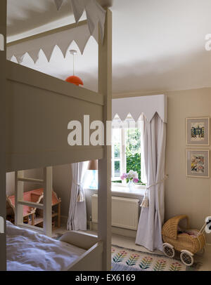 Osborn and Little striped wallpaper in kids bedroom with bunk beds and Polish folk rug Stock Photo