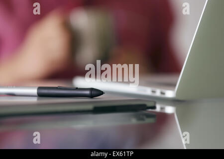 Photographer during coffee break while retouching image on laptop computer. Closeup of digital tablet and stylus pen. Copy space Stock Photo