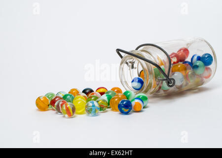 Colorful Spilled Marbles Glass Jar Metal Wire on White Background Stock Photo