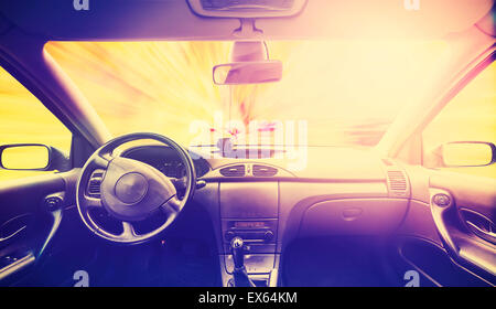 Vintage retro toned picture of a car interior at sunset. Stock Photo