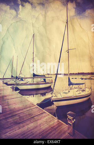 Retro old paper postcard with sailing boats at wooden pier. Stock Photo