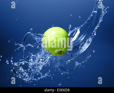 Green apple with water splash on blue water background Stock Photo