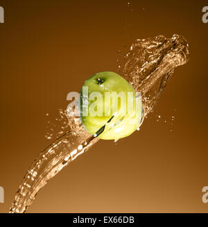 Green apple with water splash on beige background Stock Photo