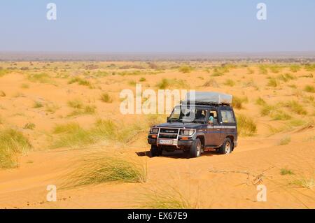 SUV with roof tent on the road in the desert, route from Atar to Tidjikja, Adrar region, Mauritania Stock Photo