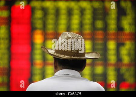 Nantong, China. 08th July, 2015. An investor watches the eclectic monitor at a stock exchange in Huaibei, Anhui province, China on 8th July 2015. The CSI300 index of the largest listed companies in Shanghai and Shenzhen close down 6.8 percent, while the Shanghai Composite Index dropped 5.9 percent. Credit:  Panda Eye/Alamy Live News Stock Photo