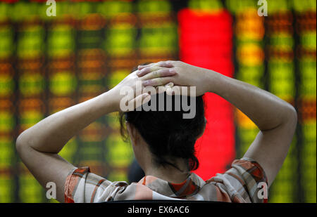 Nantong, China. 08th July, 2015. An investor watches the eclectic monitor at a stock exchange in Huaibei, Anhui province, China on 8th July 2015. The CSI300 index of the largest listed companies in Shanghai and Shenzhen close down 6.8 percent, while the Shanghai Composite Index dropped 5.9 percent. Credit:  Panda Eye/Alamy Live News Stock Photo