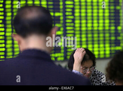 Nantong, China. 08th July, 2015. An investor watches the eclectic monitor at a stock exchange in Nantong, Jiangsu province, China on 8th July 2015. The CSI300 index of the largest listed companies in Shanghai and Shenzhen close down 6.8 percent, while the Shanghai Composite Index dropped 5.9 percent. Credit:  Panda Eye/Alamy Live News Stock Photo