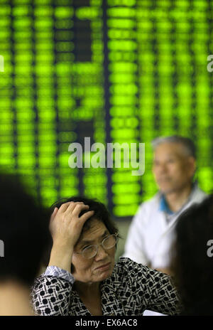 Nantong, China. 08th July, 2015. An investor watches the eclectic monitor at a stock exchange in Nantong, Jiangsu province, China on 8th July 2015. The CSI300 index of the largest listed companies in Shanghai and Shenzhen close down 6.8 percent, while the Shanghai Composite Index dropped 5.9 percent. Credit:  Panda Eye/Alamy Live News Stock Photo