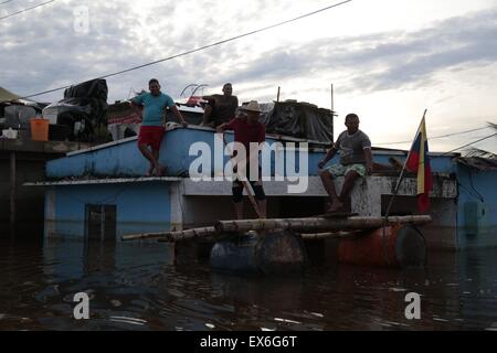 Apure, Venezuela. 7th July, 2015. People move on board a improvised boat in a flooded street in the town of Guasdualito, Apure state, Venezuela, on July 7, 2015. According to local press, more than 9,000 families were affected by the floods caused by the overflowing of the rivers Arauca and Sarare. Credit:  Str/Xinhua/Alamy Live News Stock Photo