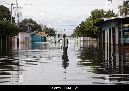 Apure, Venezuela. 7th July, 2015. A person walks in a flooded street in the town of Guasdualito, Apure state, Venezuela, on July 7, 2015. According to local press, more than 9,000 families were affected by the floods caused by the overflowing of the rivers Arauca and Sarare. Credit:  Str/Xinhua/Alamy Live News Stock Photo