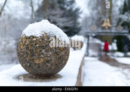 Snow on Clare College bridge with lady in red coat in the distance, Cambridge UK Stock Photo