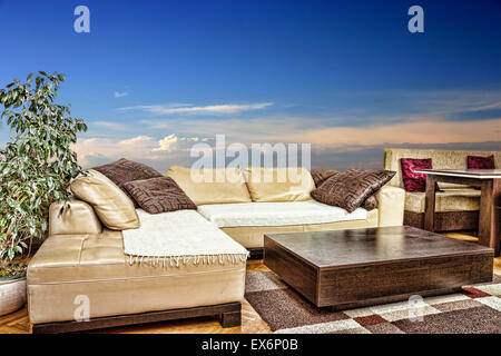 Empty living room with angular or corner sofa and low table. Interior in modern and classic design, with blue and little red sky Stock Photo