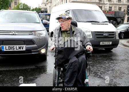 A wheelchair user in the Middle of the road during a  protest against government cuts Stock Photo