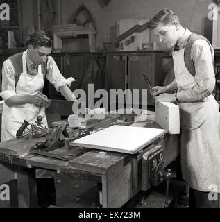 1950s, historical, two young male woodwork students or apprentices working with materials at bench. Stock Photo