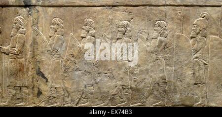 Relief depicting The royal lion hunt. Assyrian, about 645-635 BC From Nineveh, North Palace. Grooms lead horses towards a screened enclosure, within which the royal chariot is being prepared for the hunt. Men struggle to push one horse into position; the Stock Photo