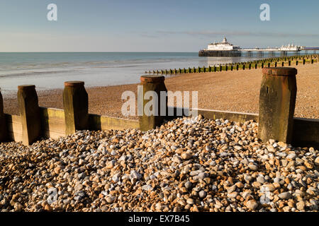 Groynes  and the pier on a pebble beach in Eastbourne, East Sussex, England Stock Photo