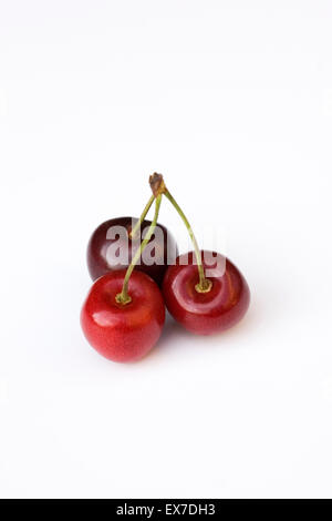 Three cherries on a white background. Stock Photo
