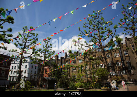 Summertime in London, England, UK. Bunting up in preparation of a fete in the park outside Saint Anne's Church in Soho. The churchyard around the tower and west end are now the public park of St Anne's Gardens Stock Photo