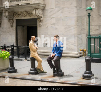 New York, USA. 8th July, 2015. A trader speaks with another employee in front of the New York Stock Exchange on Wednesday, July 8, 2015. What is being described as a technical problem halted trading on the exchange at 11:32 AM which eventually resumed at about 3:10 PM after being out for about three and one half hours. Credit:  Richard Levine/Alamy Live News Stock Photo