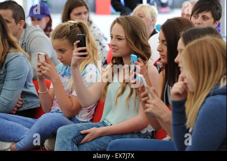 PontyPridd, Wales, UK. Crowd of teenage girls taking photographs with their phones at Festivol. © Becky Matthews Stock Photo