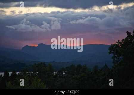 Windermere, Cumbria, UK. 08th July, 2015. The changeable British summer weather with a Dramatic Sunset photographed from the vantage point above Millerground Landing on Lake Windermere looking across the Lake to Iron Keld, Black Fell and Park Fell. Credit:  David Billinge/Alamy Live News Stock Photo