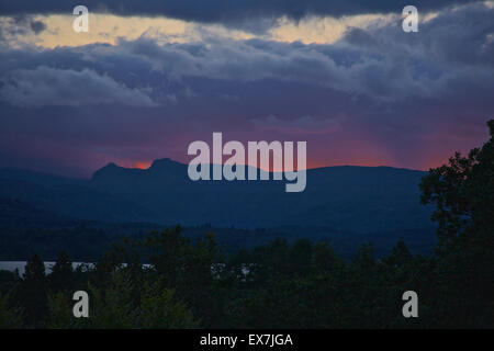 Windermere, Cumbria, UK. 08th July, 2015. The changeable British summer weather with a Dramatic Sunset photographed from the vantage point above Millerground Landing on Lake Windermere looking across the Lake to Iron Keld, Black Fell and Park Fell. Credit:  David Billinge/Alamy Live News Stock Photo